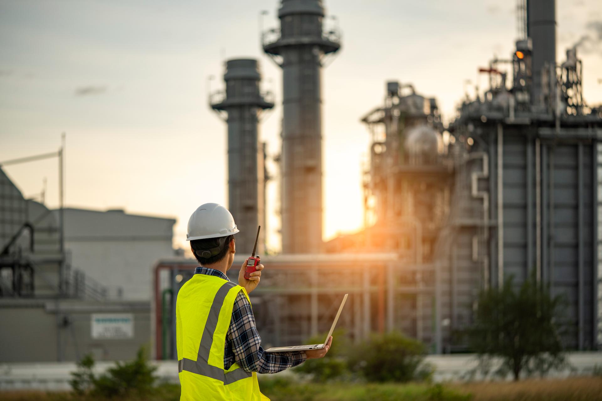 Manager Engineering in standard safety uniform working in gas turbine electric power plant during sunset or morning time background
