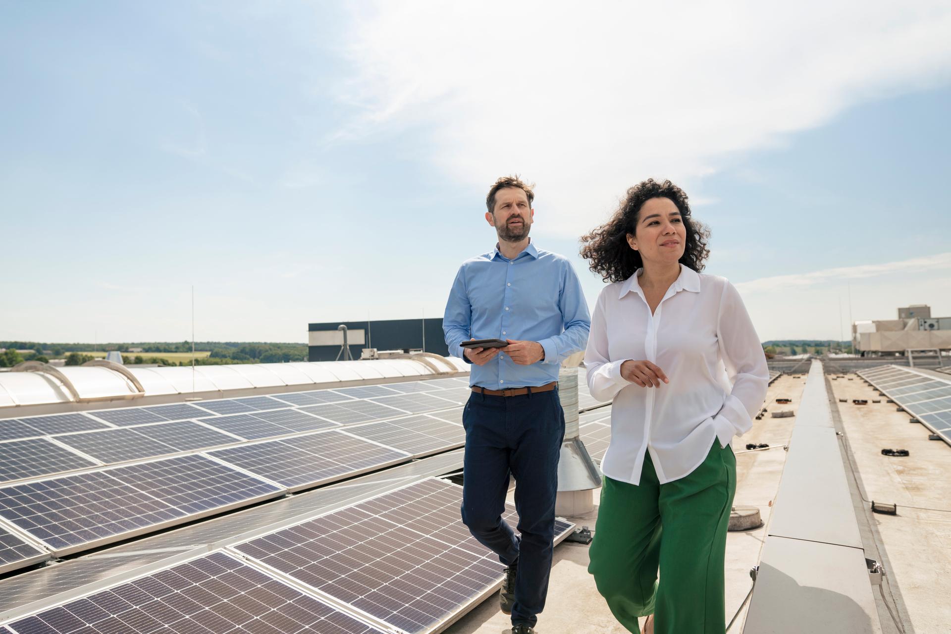 Businesswoman with businessman walking by solar panels on rooftop
Photovoltaik
PV
