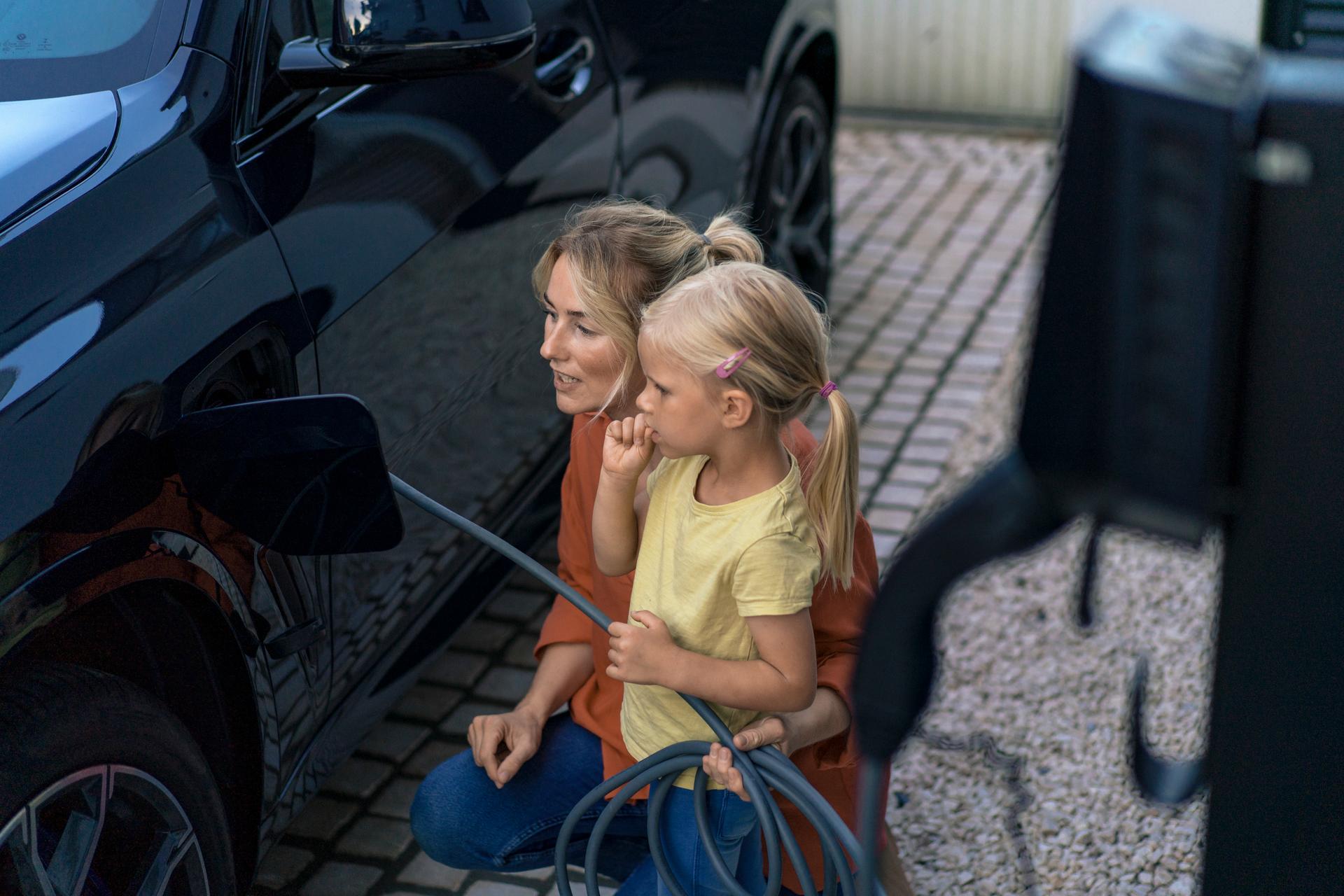 Daughter with mother charging electric vehicle in front yard
Wallbox
E-Mobilität
EMob
E-Mob
Emobilität
Auto laden
