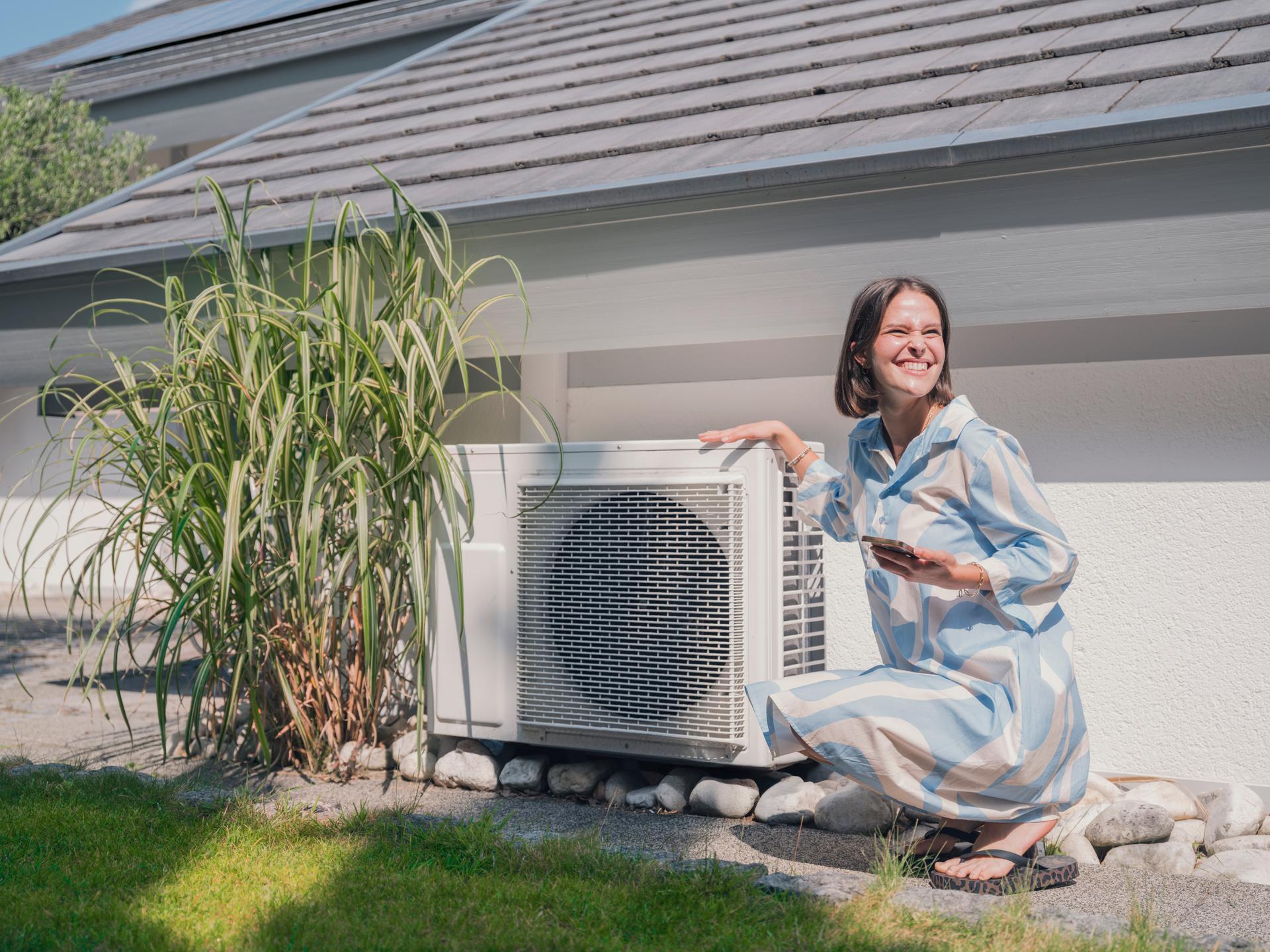 Woman kneeling outdoors checking thermal heat pump with smartphone app
Wärmepumpe
Luftwärmepumpe
Frau
Garten